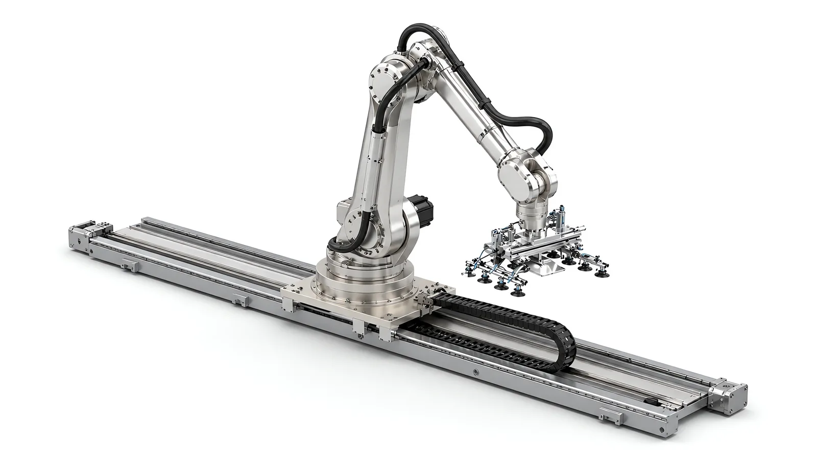 Six-axis robot on a carriage running along a low-profile linear track, the flat machined rail base bolted to the floor, an energy chain following the carriage in a central trough, end stops at both ends of the stroke and a multi-cup vacuum tool on the arm